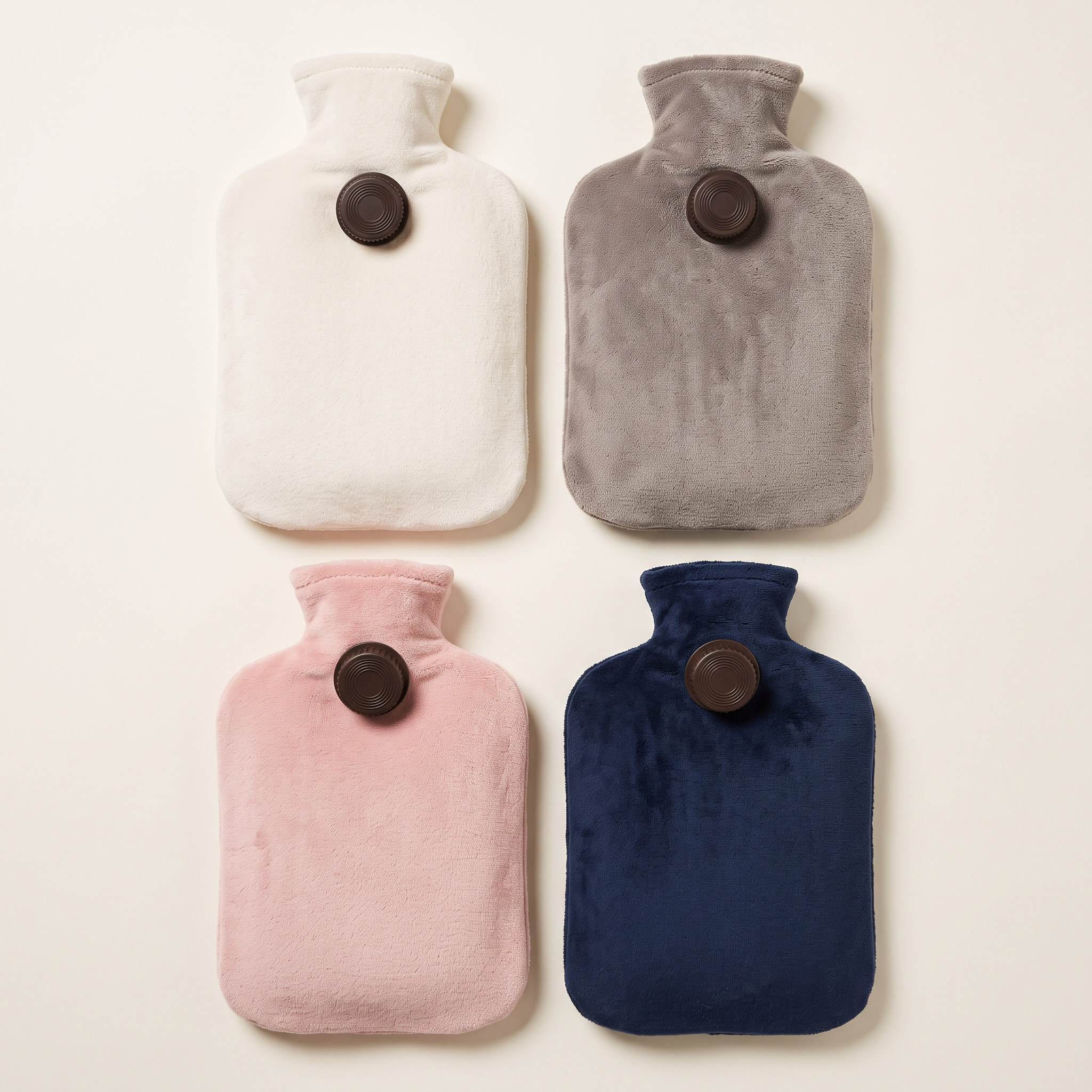 Les quatre coloris de housse peluche : écru, gris, rose poudré et bleu nuit, vus du dessus